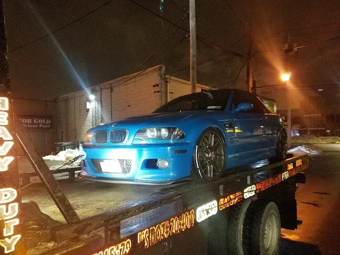 Woman in straw hat smiles, holding wine glass near a lake.