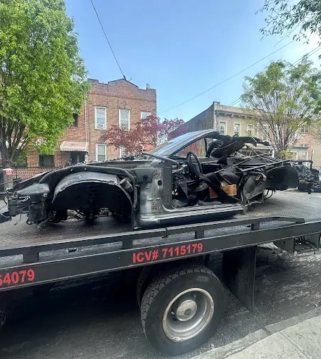 Woman in straw hat smiles, holding wine glass near a lake.