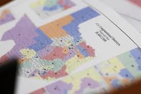 A map of US Congressional districts, multicolored with labels, on a printed paper.