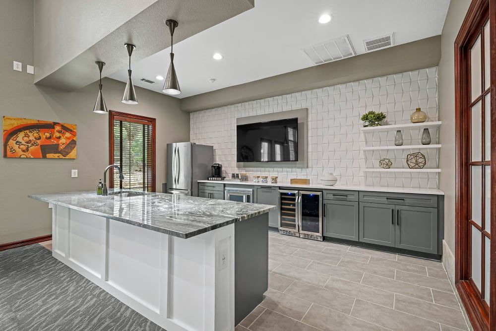 a large island in the middle of the 
clubhouse kitchen at Marquis Parkside in Austin, TX.