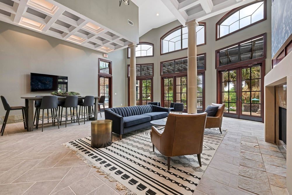 a clubhouse room with a couch, chairs, and a table at Marquis Parkside in Austin, TX.