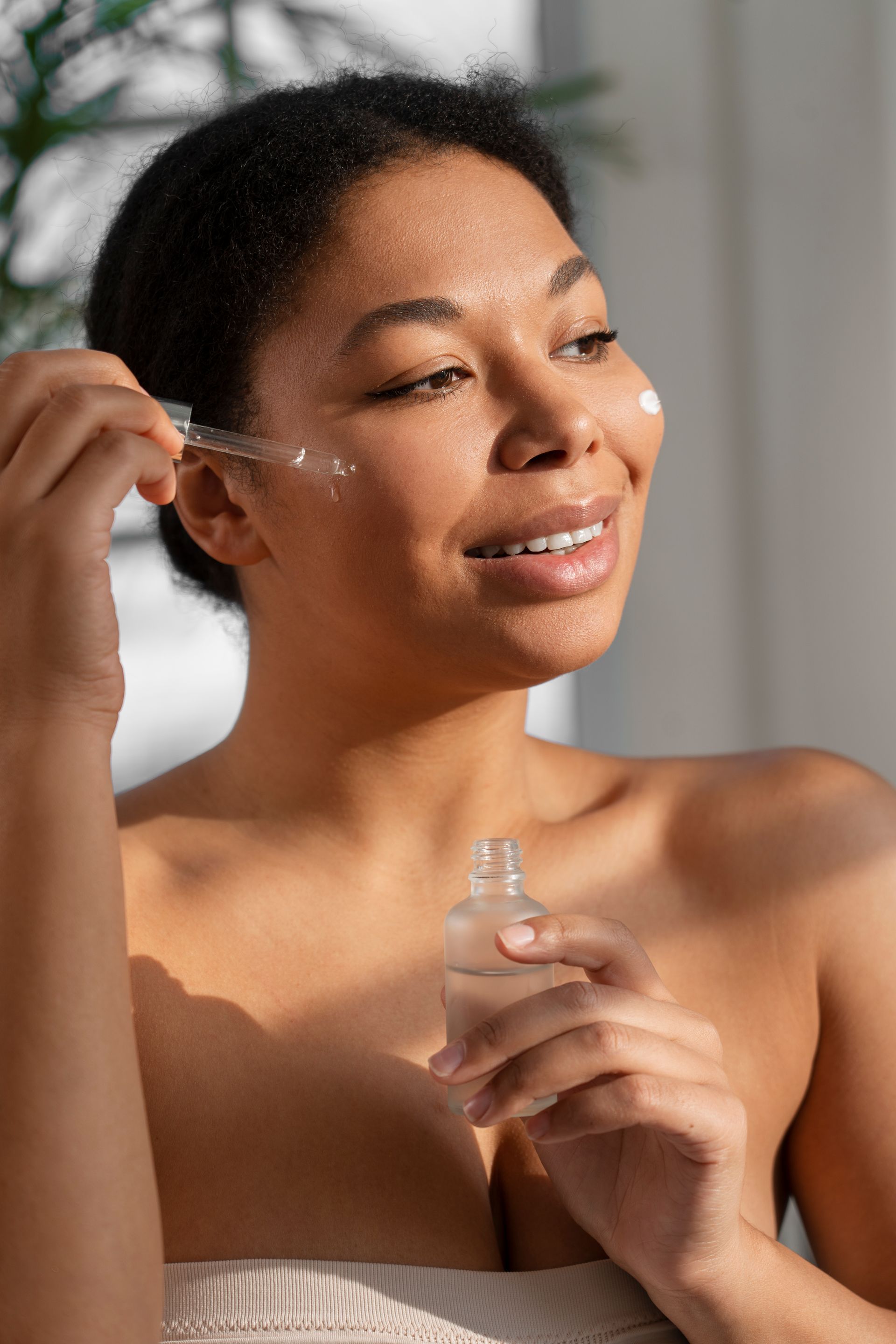 woman applying skincare serum on face