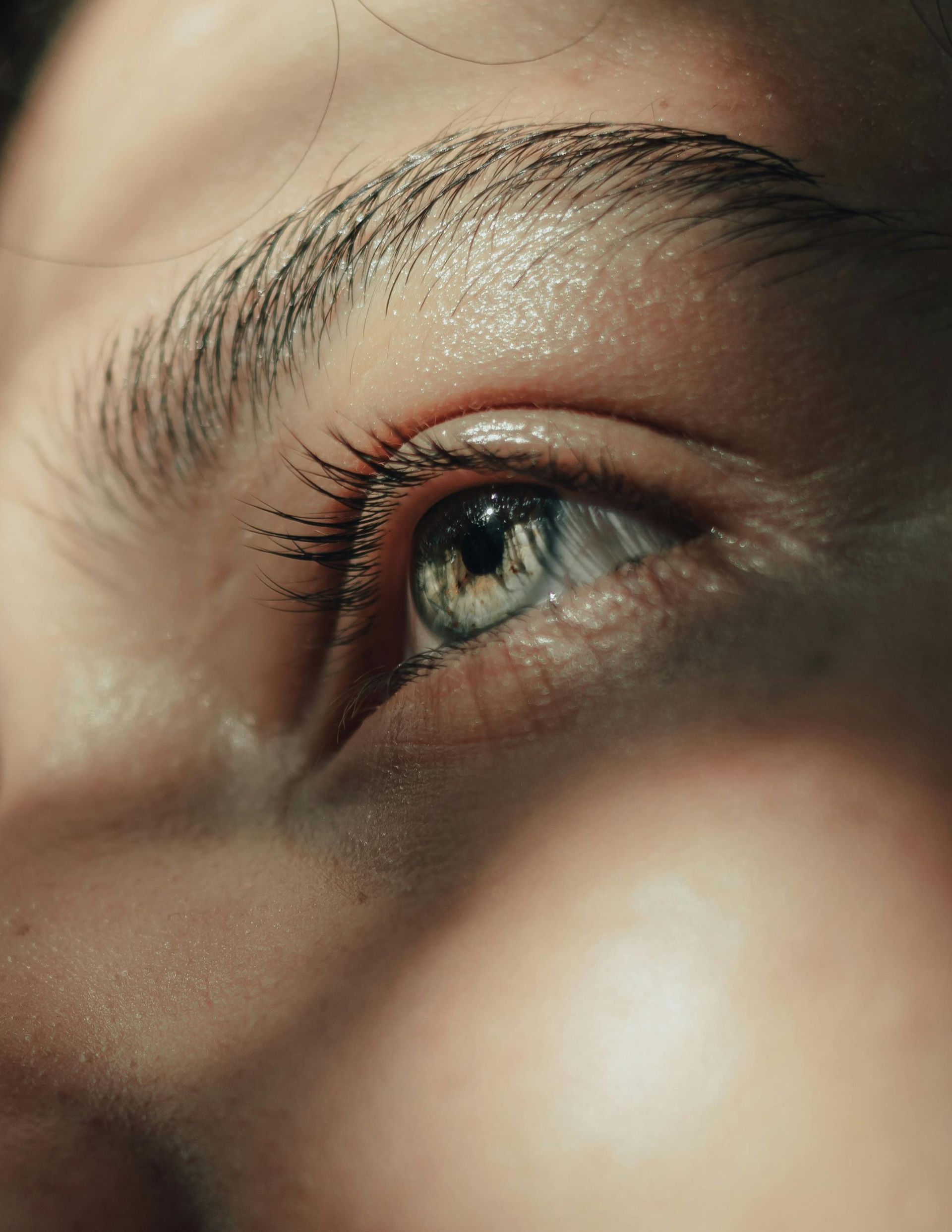 A close up of a woman 's blue eye with long eyelashes.