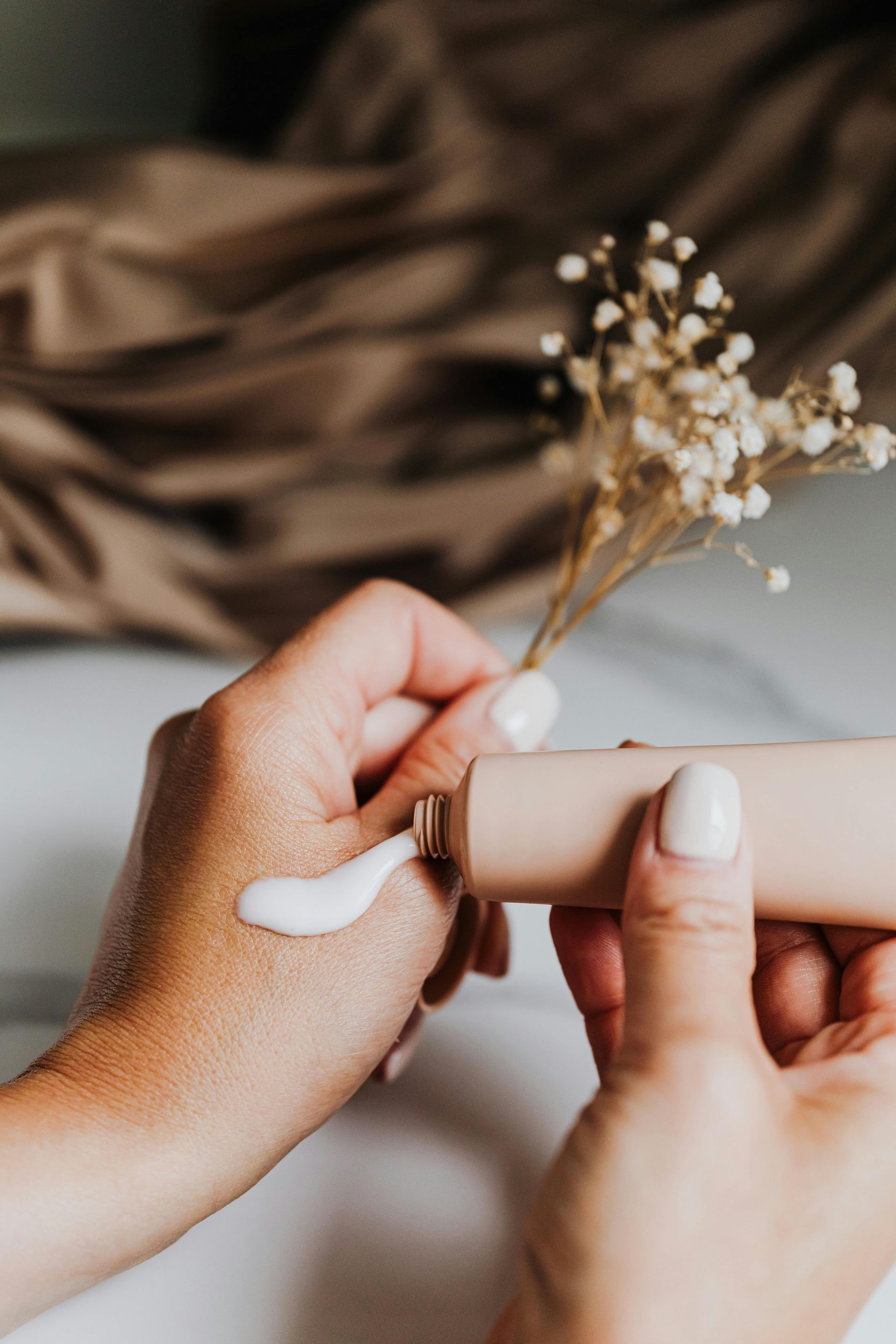 A woman is applying lotion to her hand.