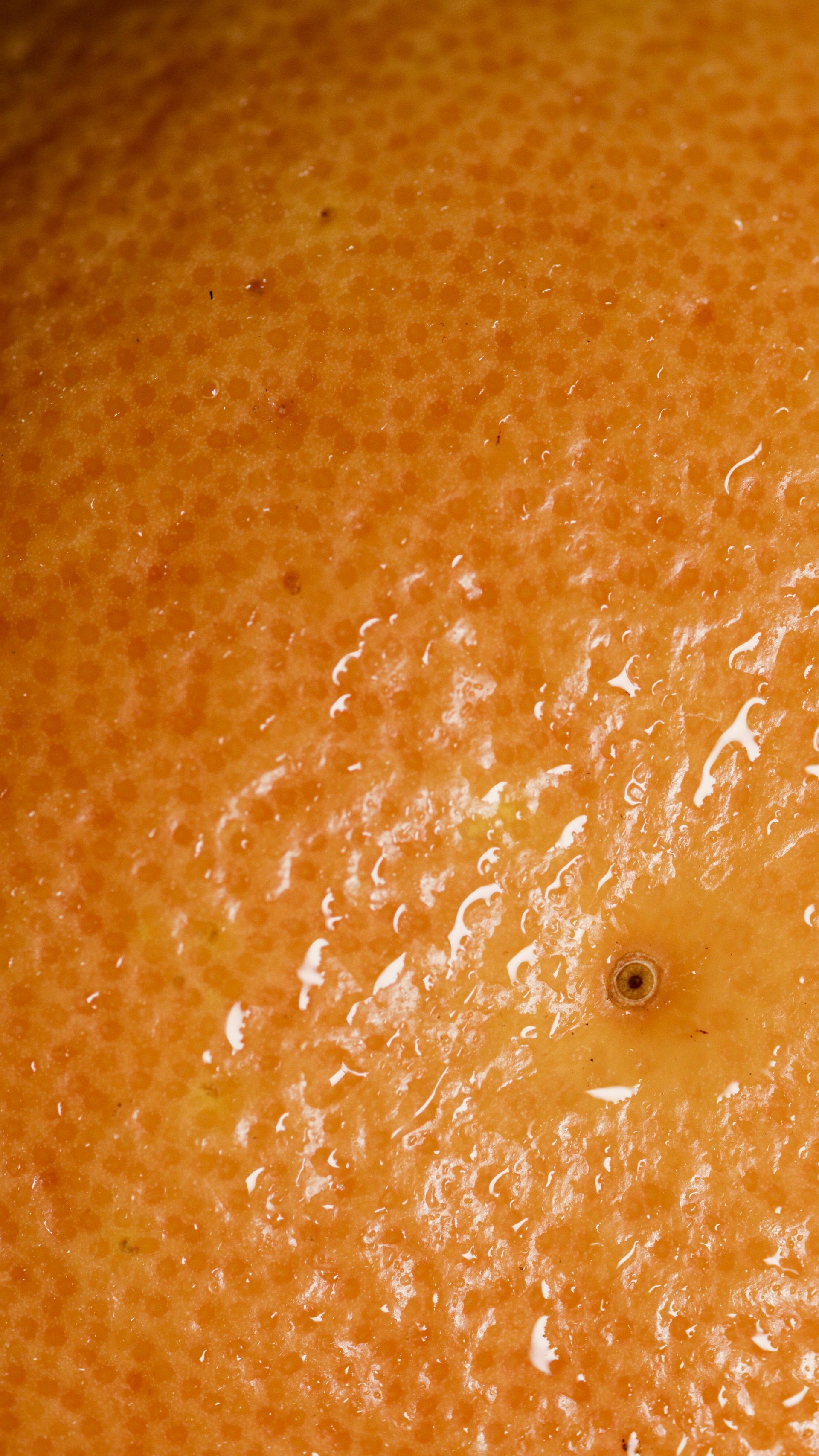 A close up of an orange peel with a hole in it.