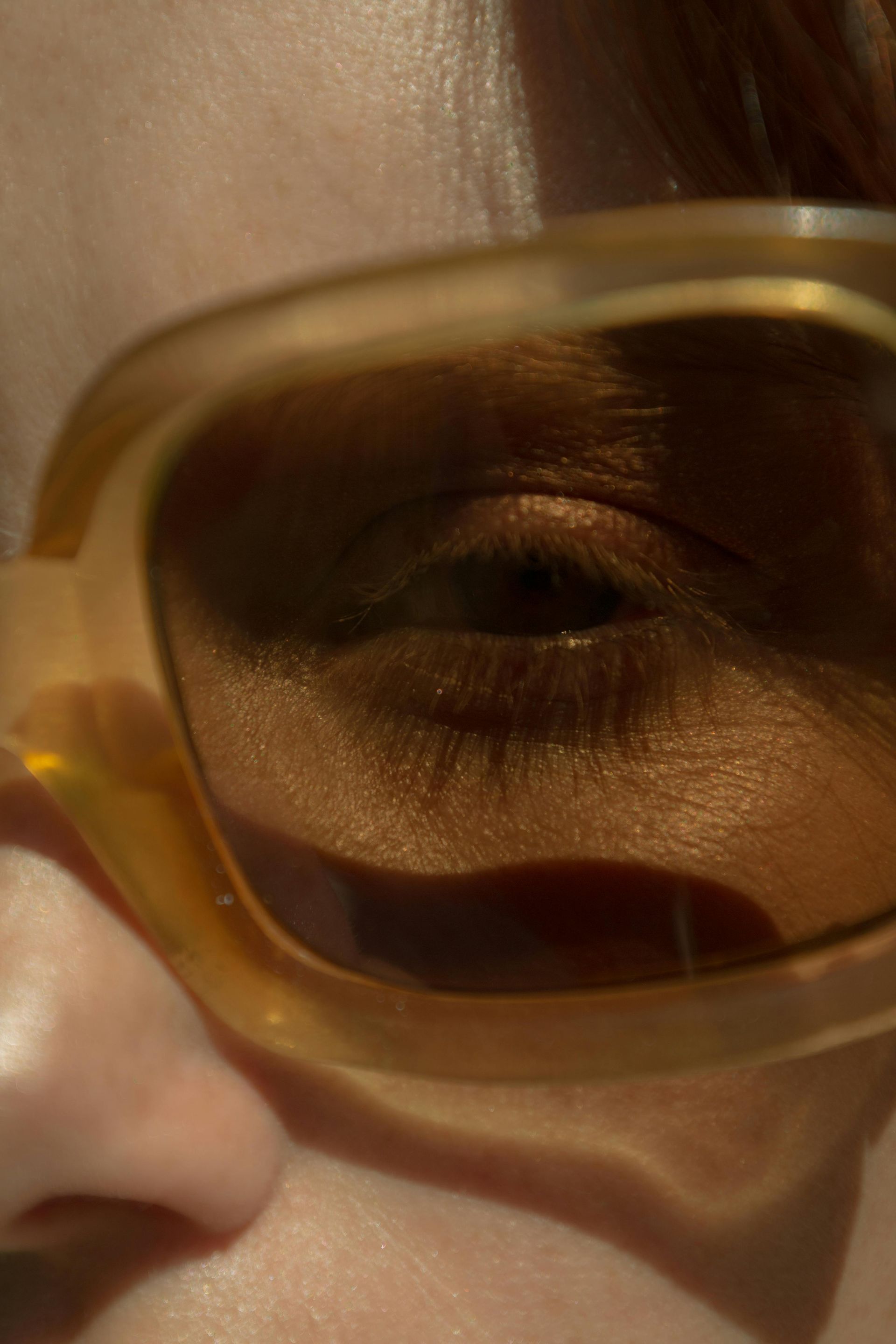 A close up of a woman 's eye wearing sunglasses.