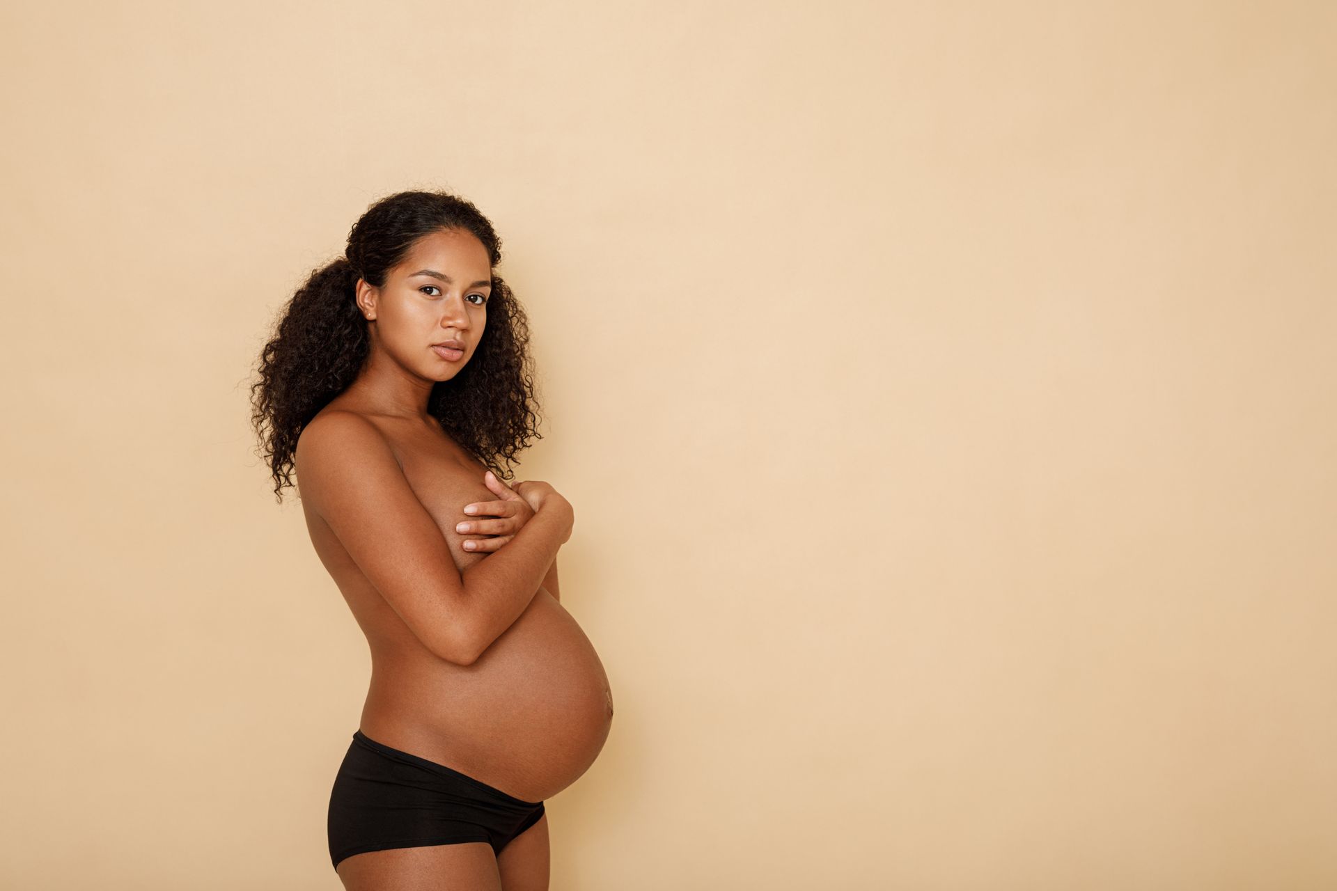 a pregnant woman covering her chest.