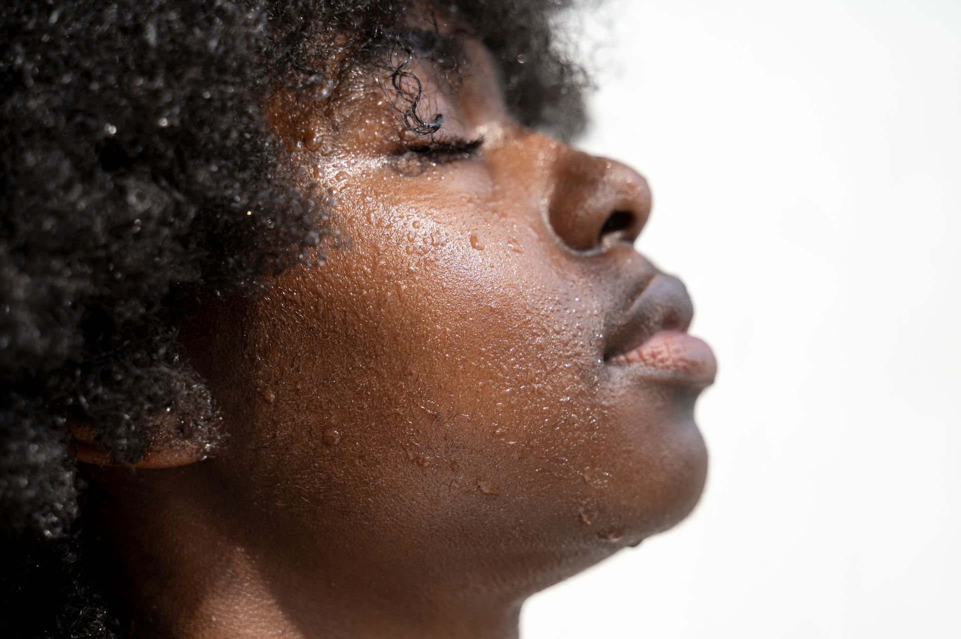 A close up of a man 's face with sweat on it.