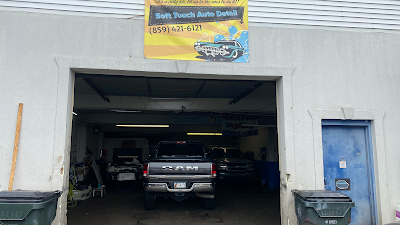 A ram truck is parked in the garage of a car repair shop.