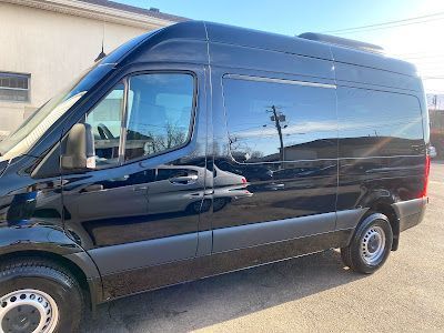 A black van is parked in front of a building.