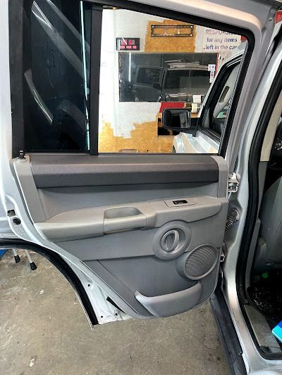 The back door of a silver jeep is open.