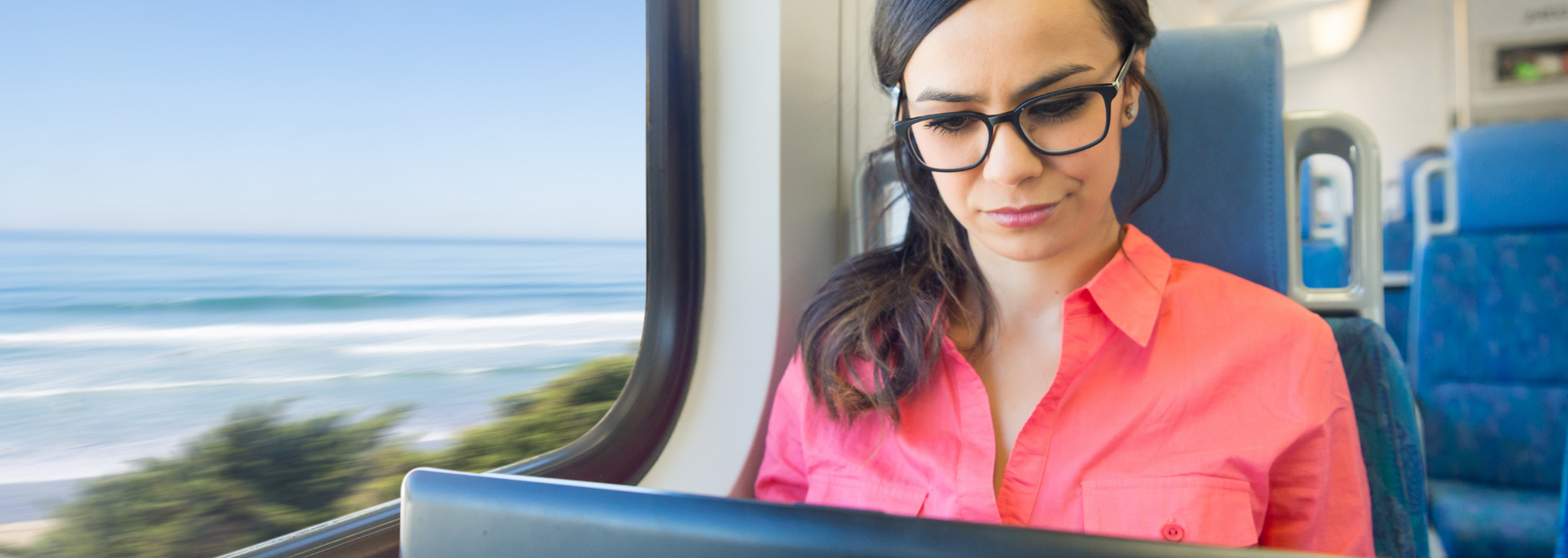 Picture of a professional using a laptop on a train.
