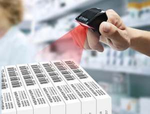 A person is using a barcode scanner (Hyco Ring Scanner) to scan a stack of boxes.