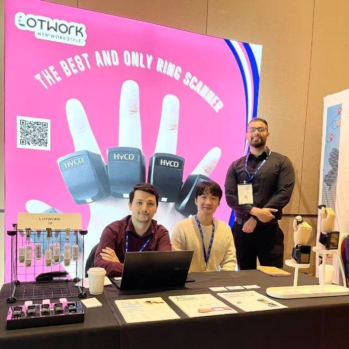 Lotwork team showcasing HYCO ring scanners at a tech expo booth for smart warehouse solutions.