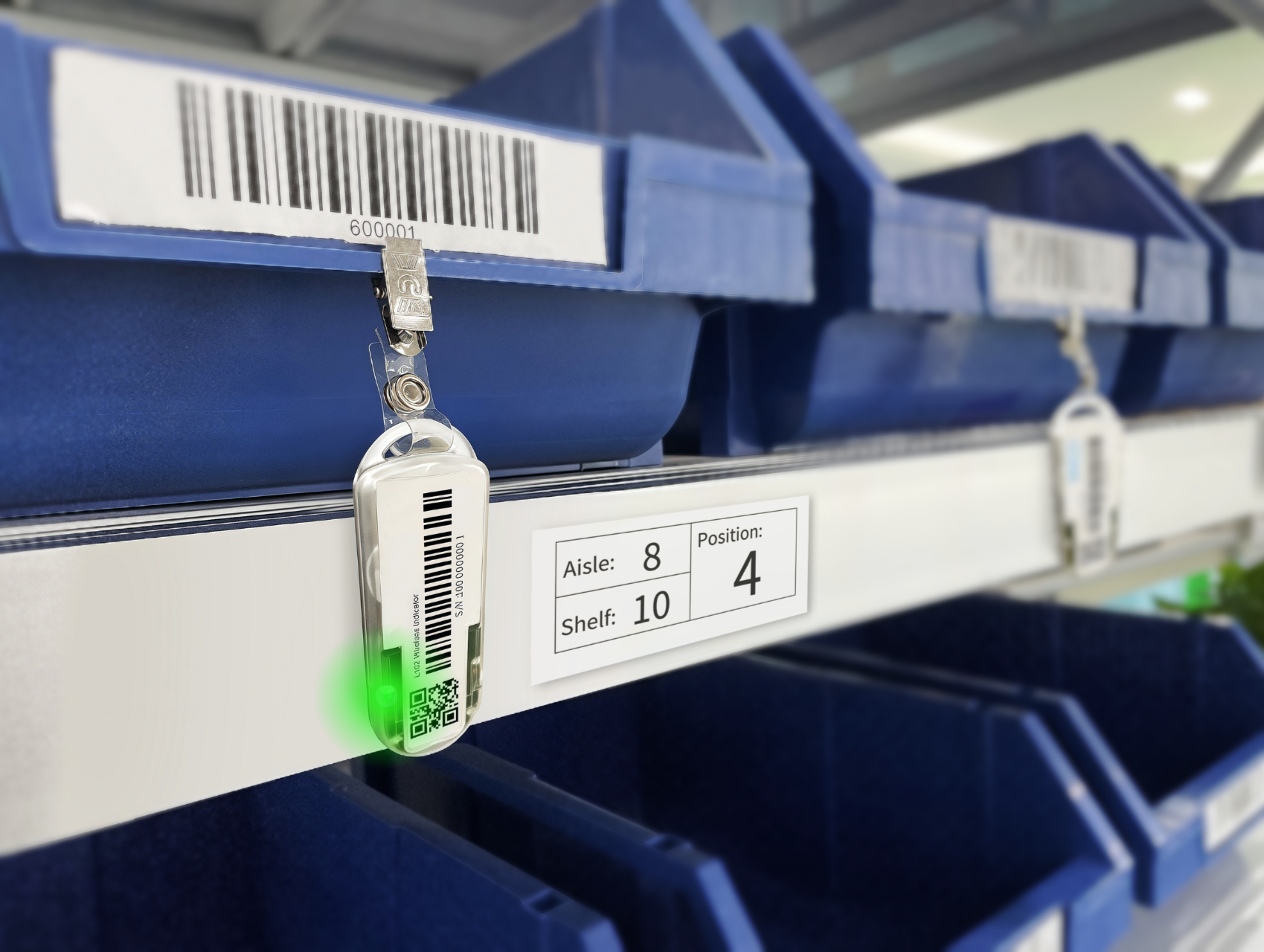 Close-up of blue storage bins with attached labels and a Wireless Light Tag glowing green.