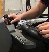 A person wearing Hyco Ring Scanner is sitting in a chair holding a steering wheel.