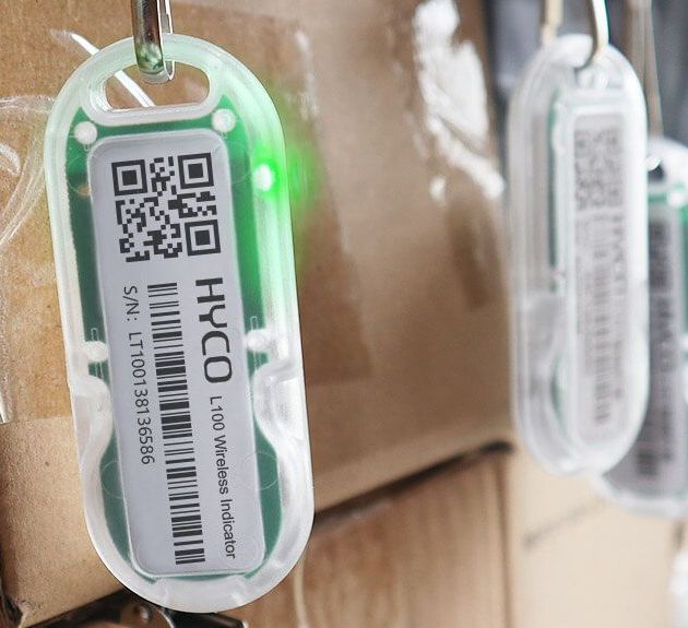 A (L102 Chargeable Wireless Light Tag) with a green light on it