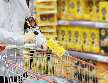 A person is pushing a shopping cart in a grocery store.  W563 Wearable Compute