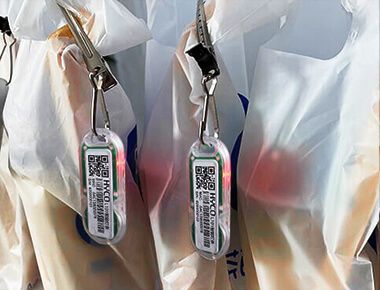 A close up of a bunch of bags with (L102 Chargeable Wireless Light Tag) attached to them.