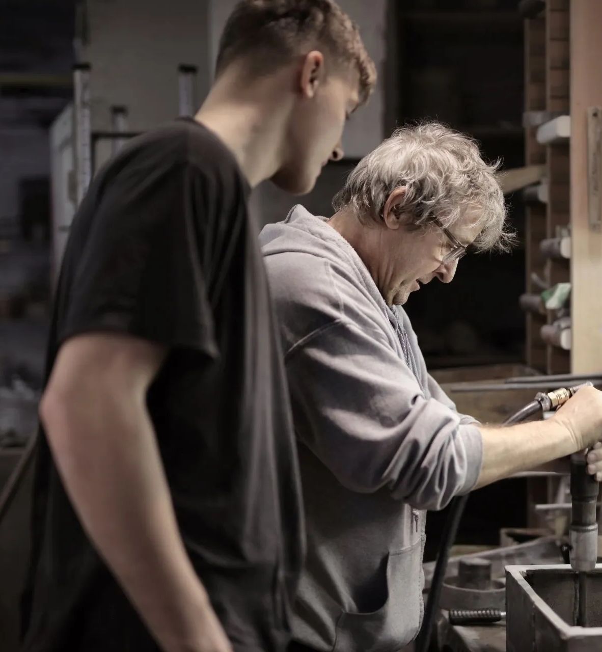 Two men are working on a machine in a dark room