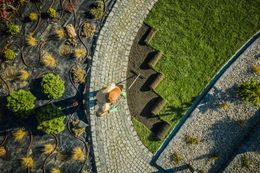 Aerial view of a garden with stone path and person working on a newly sodded area.