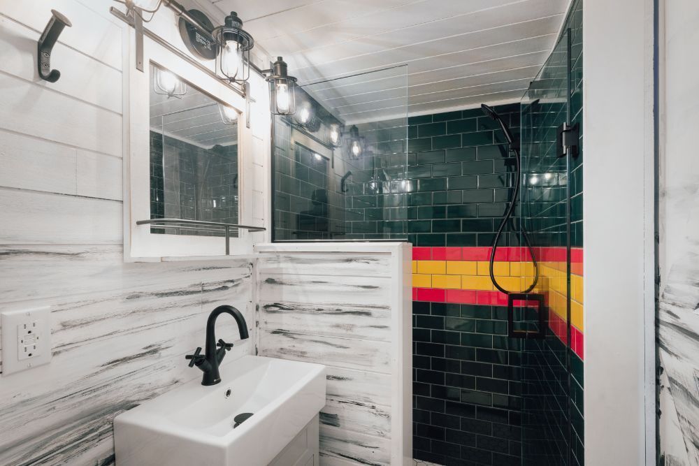 A bathroom with a sink , mirror , and shower.