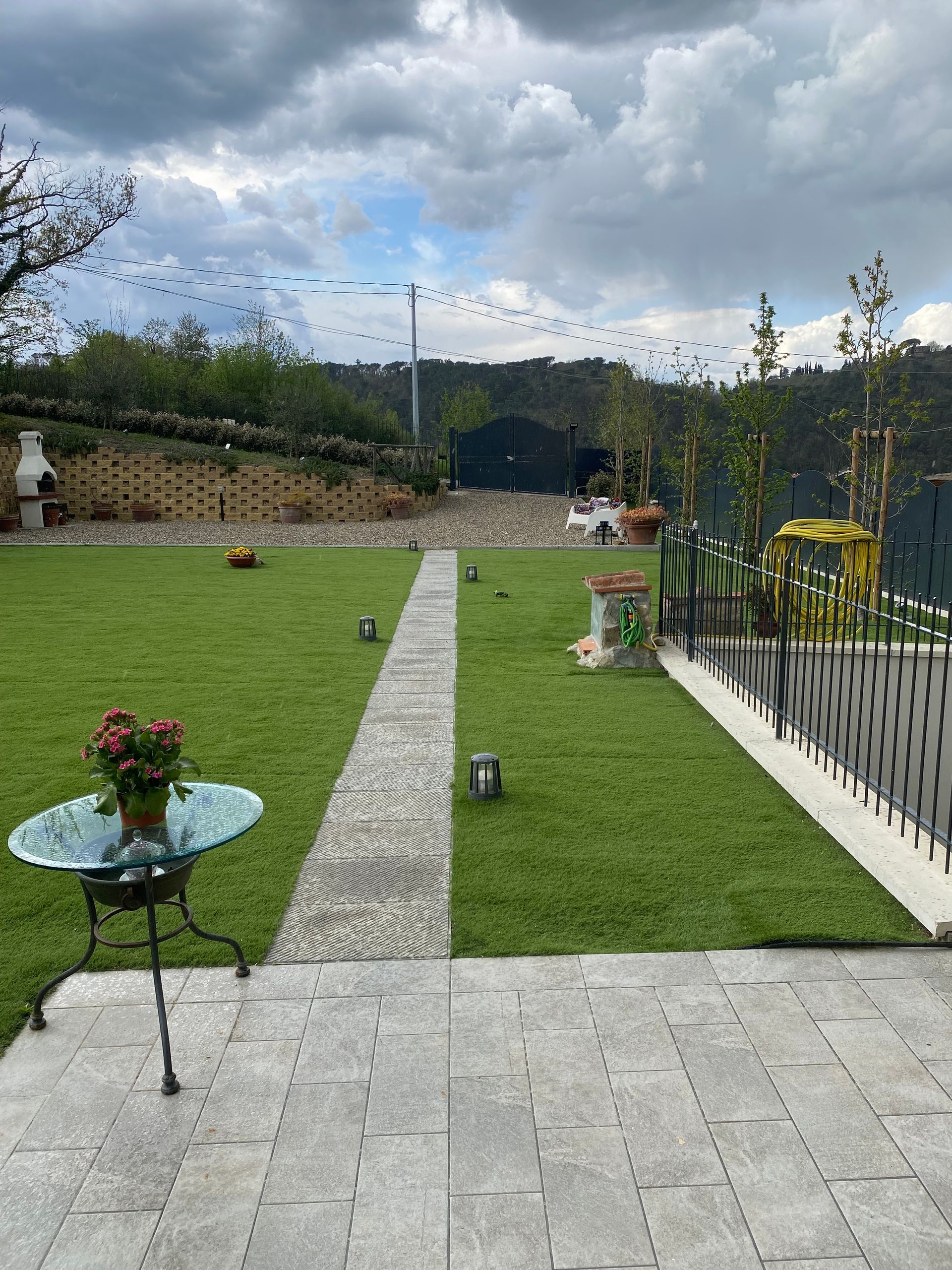 Gradini in pietra che salgono su un giardino in collina, con erba che cresce tra i gradini.