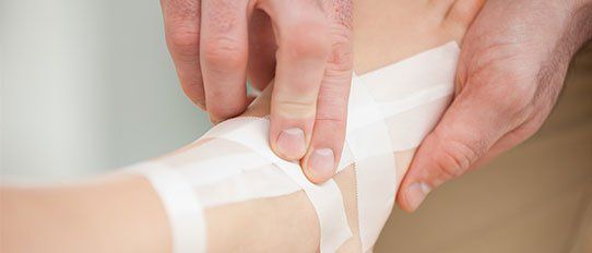 Serious practitioner bandaging an ankle - foot care, ankle care in Muscatine, IA