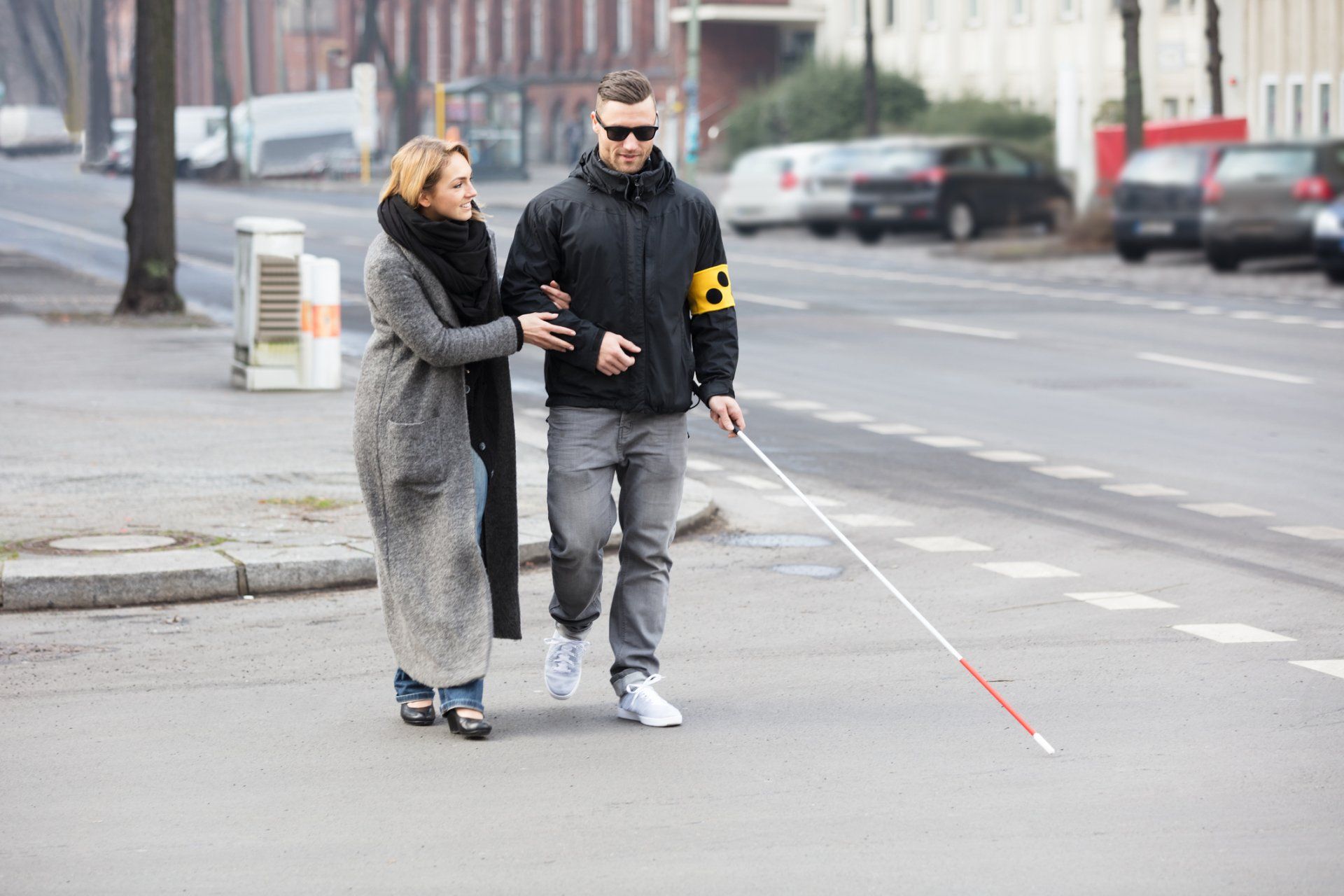 Blind Man Assisted By A Woman