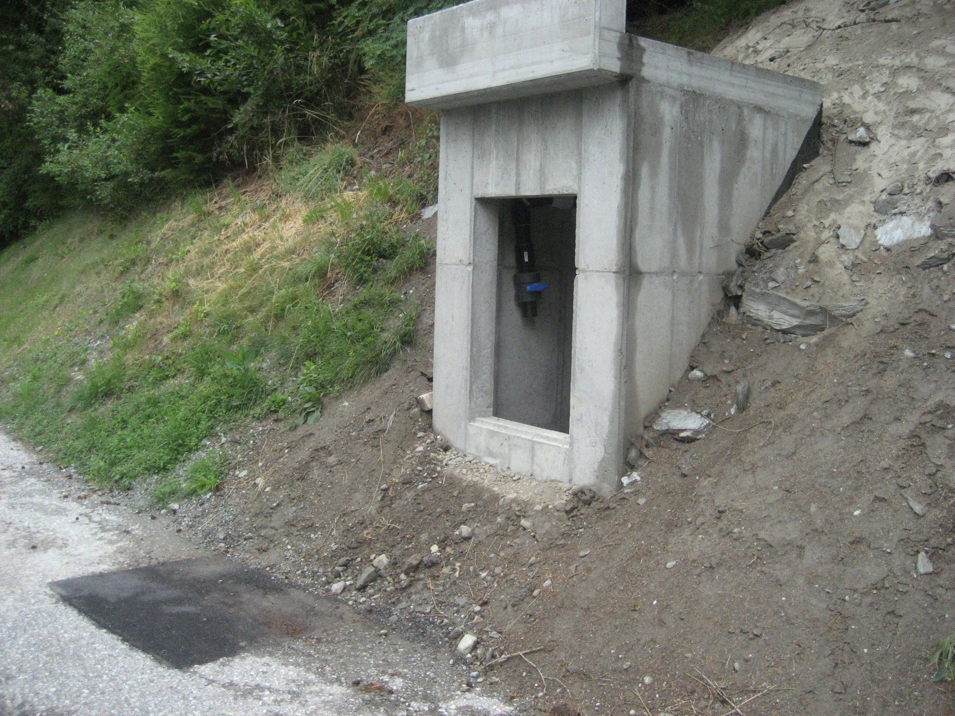 Un petit bâtiment en béton au bord d'une route