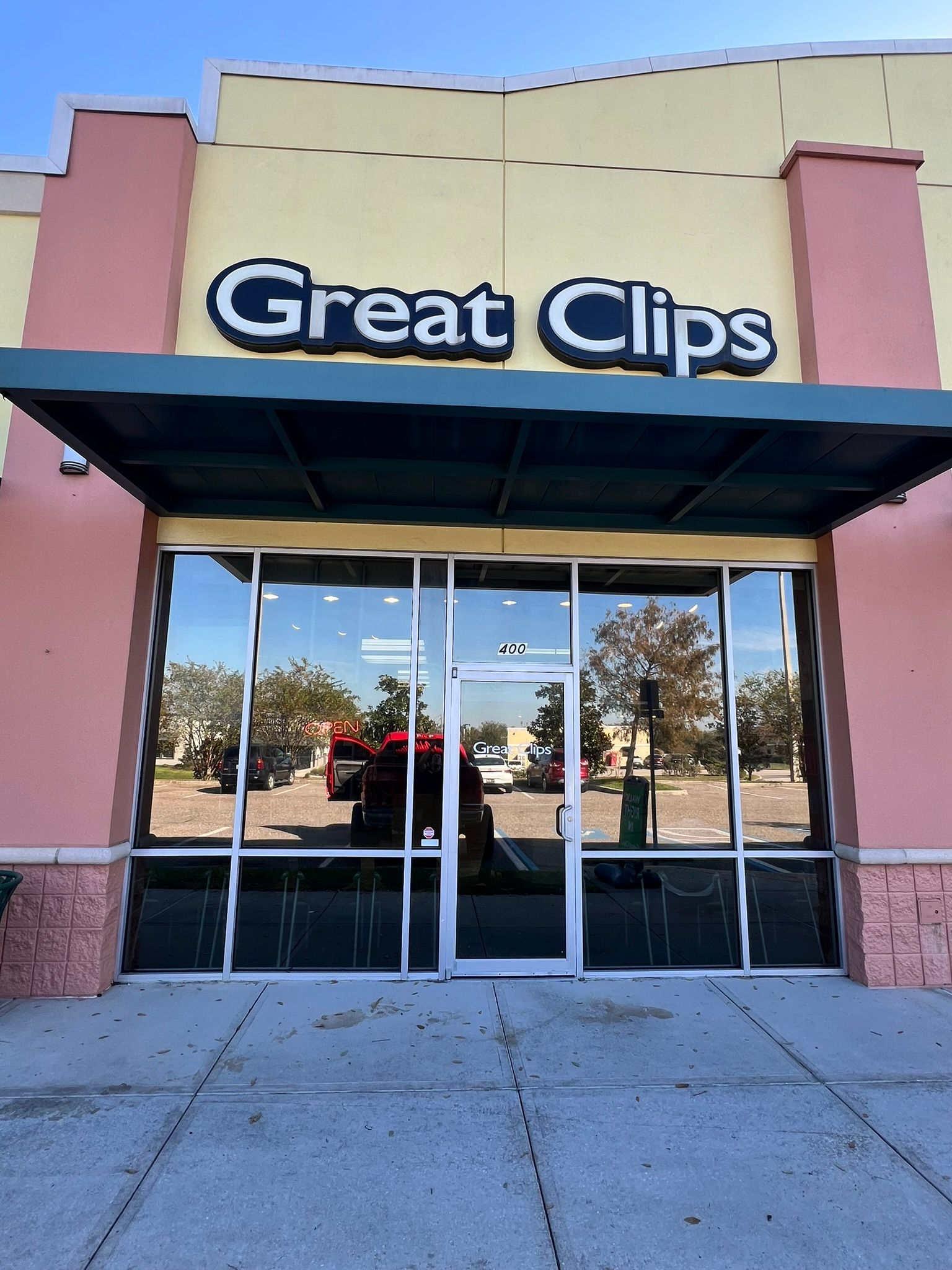 Great Clips storefront with glass doors, a dark awning, and sign.
