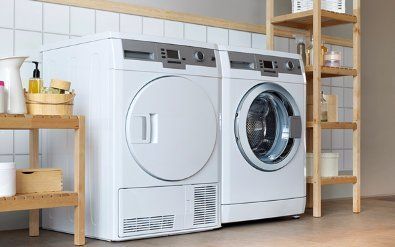 A washer and dryer are sitting next to each other in a laundry room.
