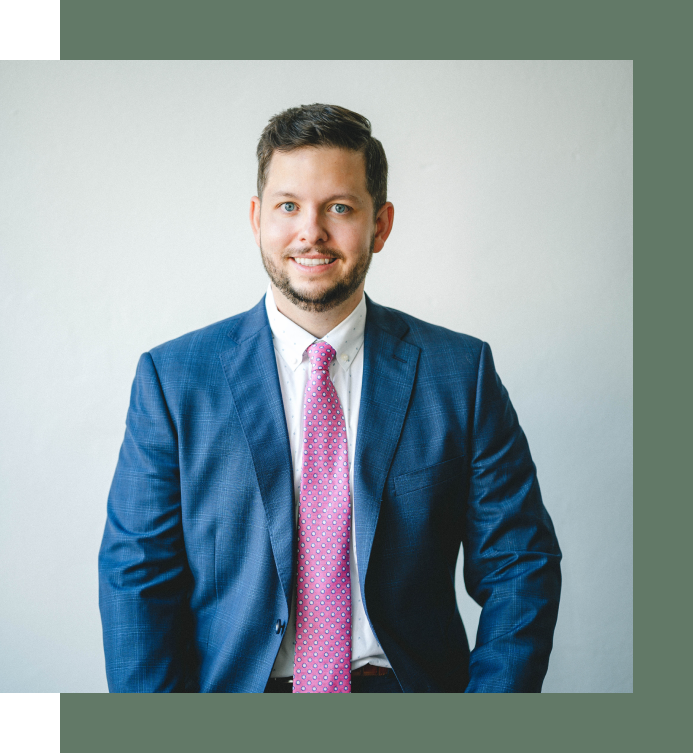 A man in a suit and tie is smiling for the camera