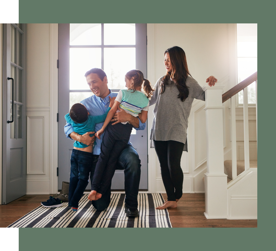 A family is standing in front of a door in a house.