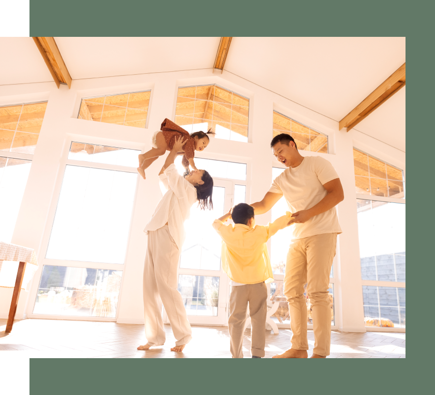 A family is playing in a room with lots of windows