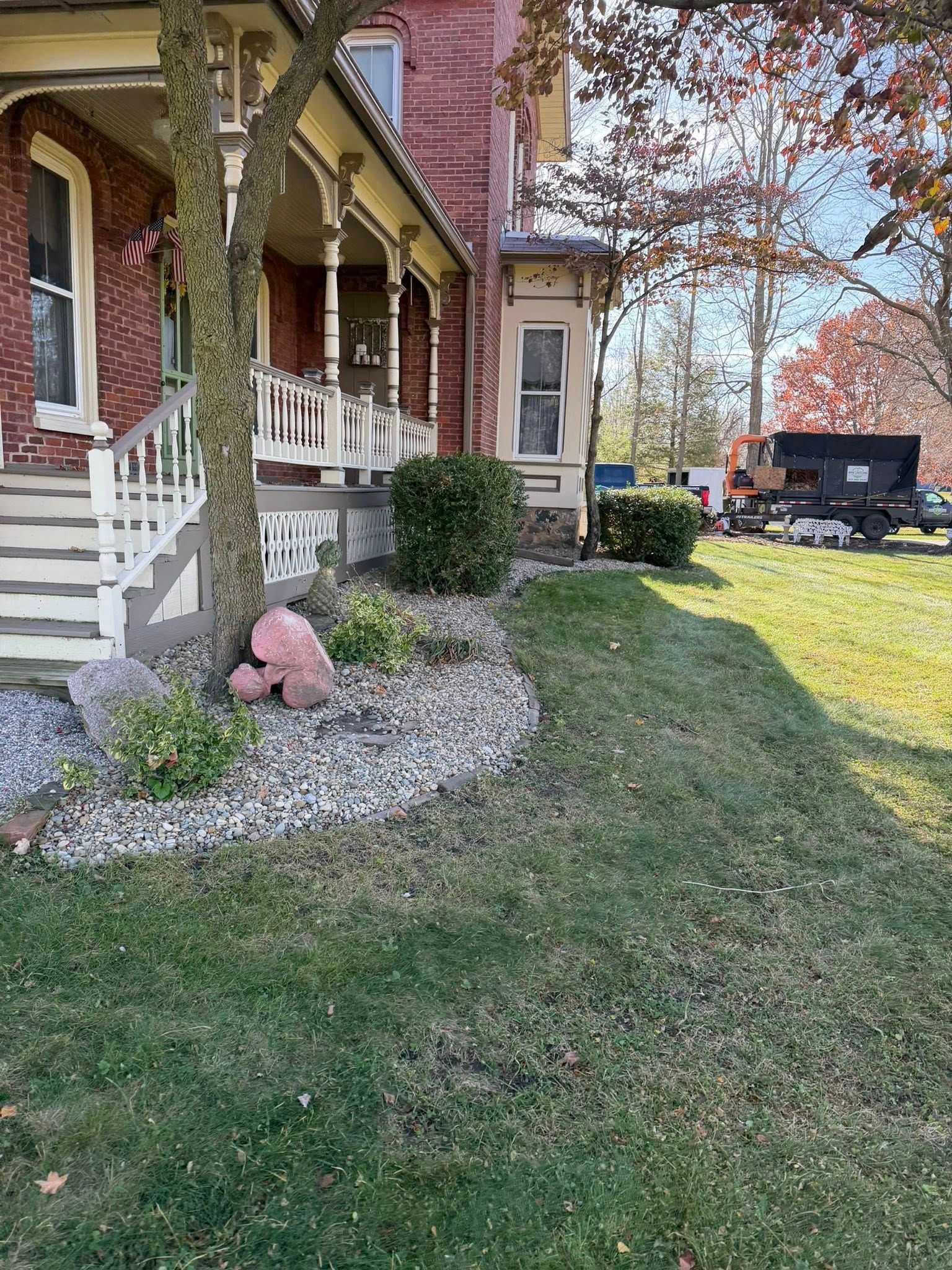 A house with a porch, landscaping, and a truck on the side.