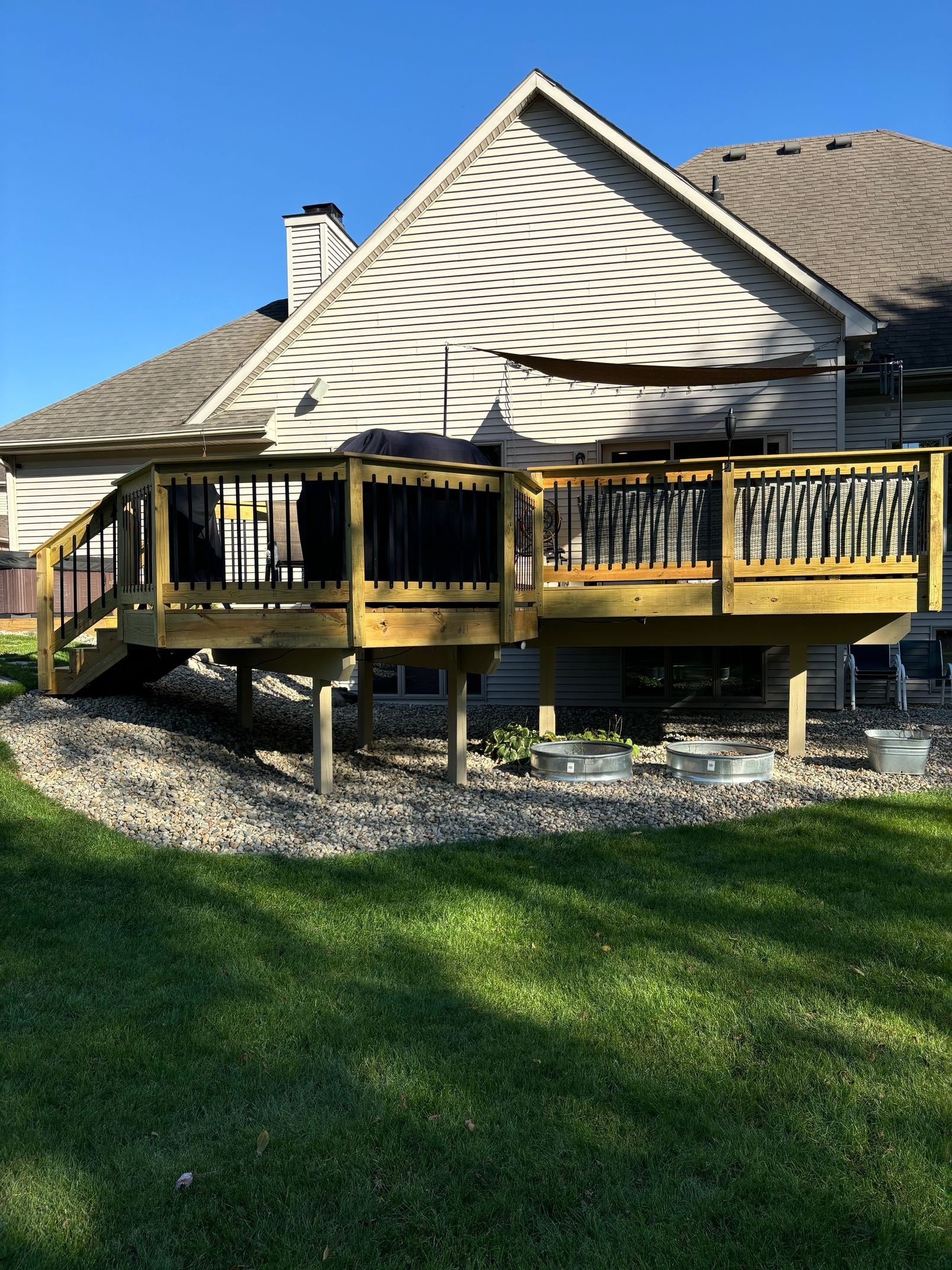 A house with a large wooden deck in front of it.