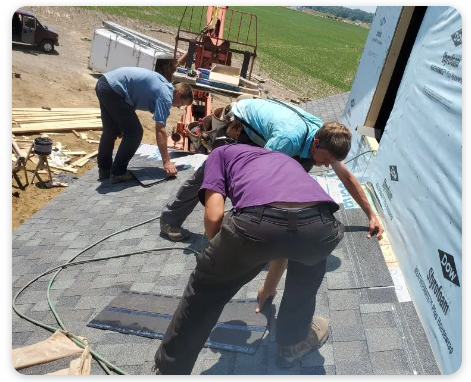 Close-up of a roofing contractor installing a new asphalt roof with a hammer.