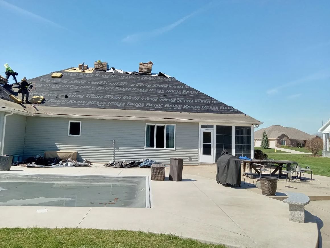 A Man Is Working on A Metal Roof with A Drill | Shelbyville, IN | SL Construction