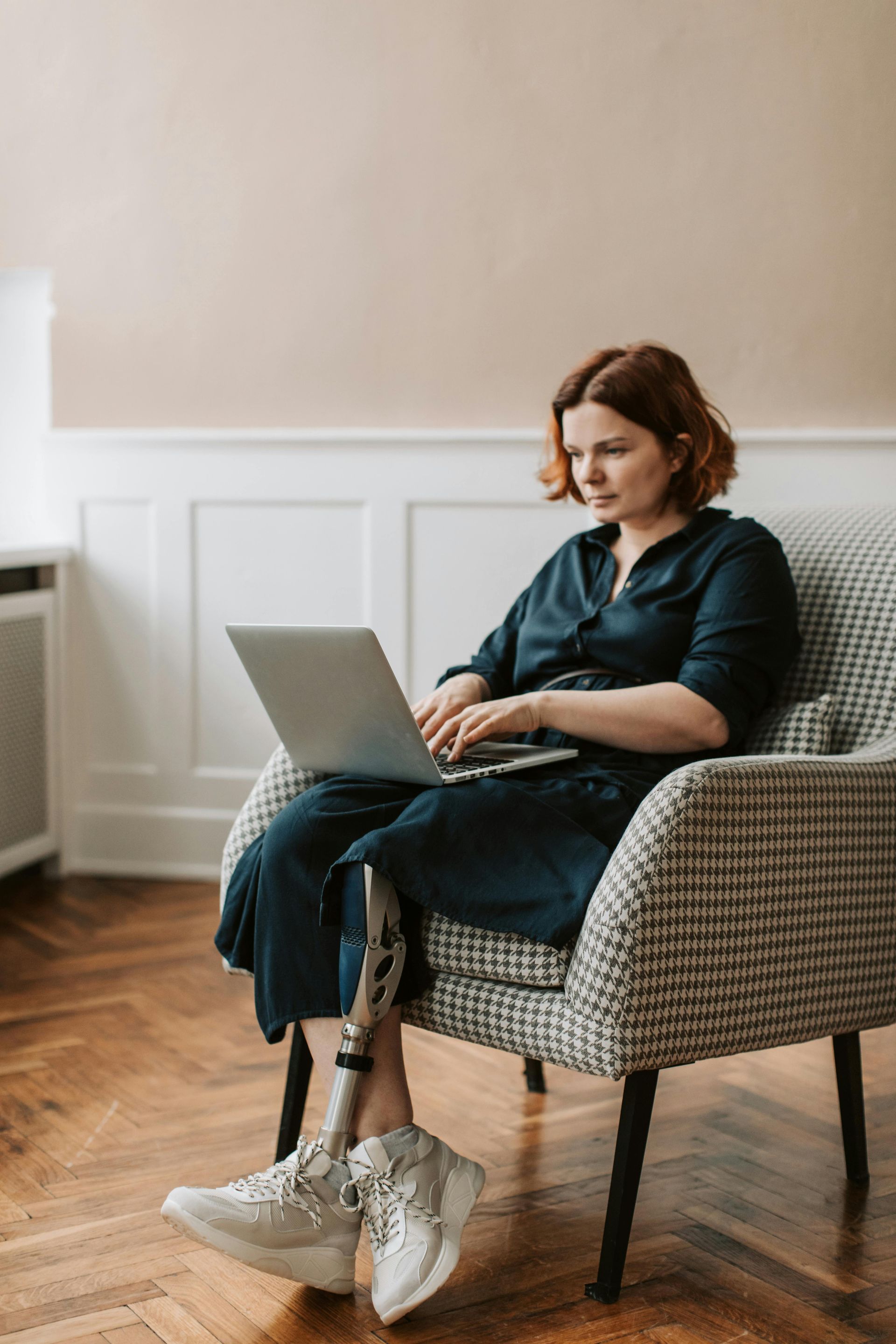 Woman with Prosthetic Leg on Computer