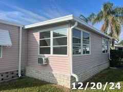 A mobile home with a lot of windows and a palm tree in the background.
