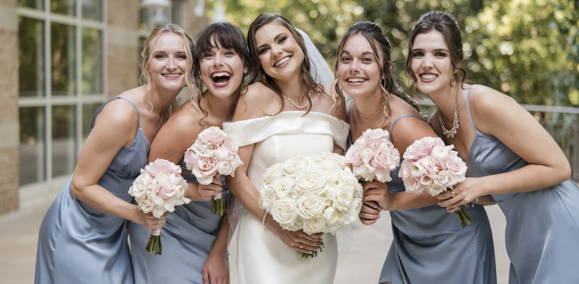 A bride and her bridesmaids are posing for a picture.