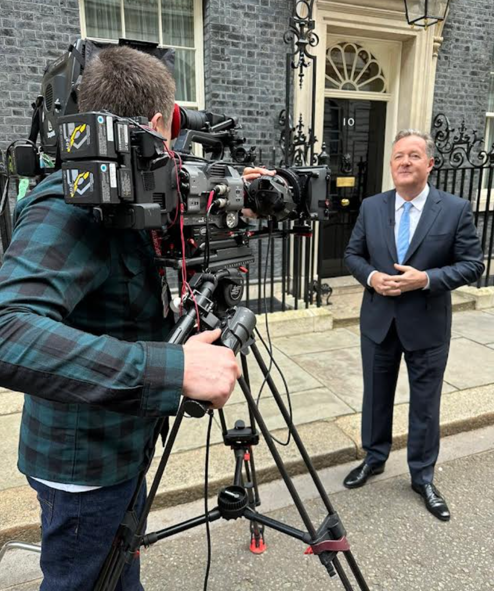 A man in a suit is being interviewed by a cameraman