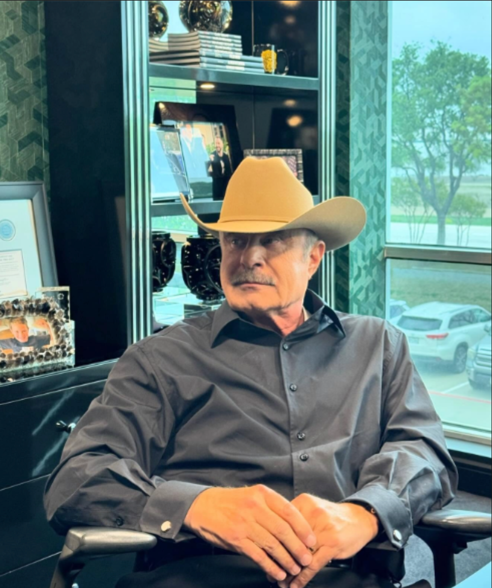 A man wearing a cowboy hat is sitting in a chair