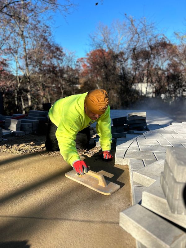 A bulldozer is being towed by a truck in a parking lot.