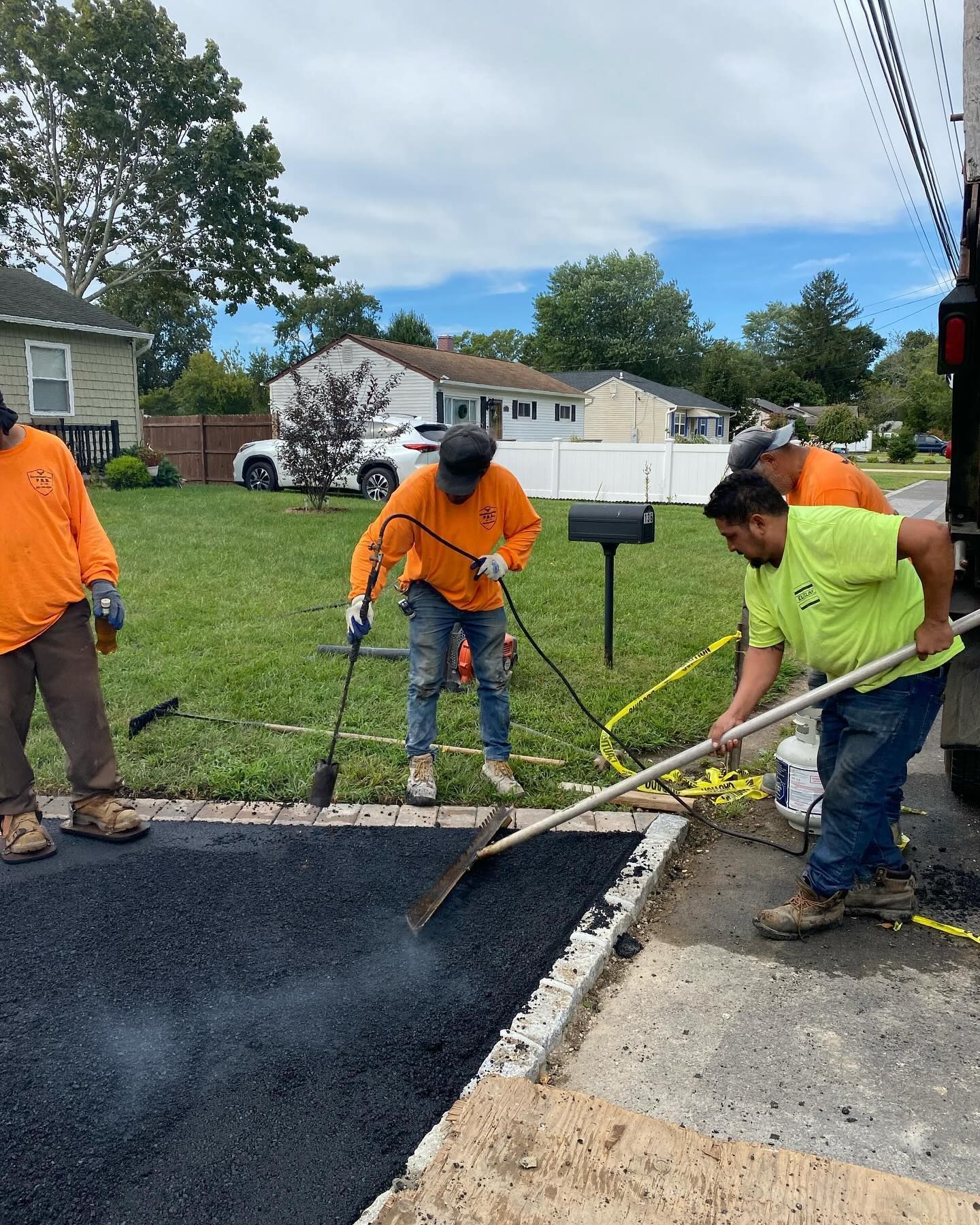 A group of men are working on a driveway.