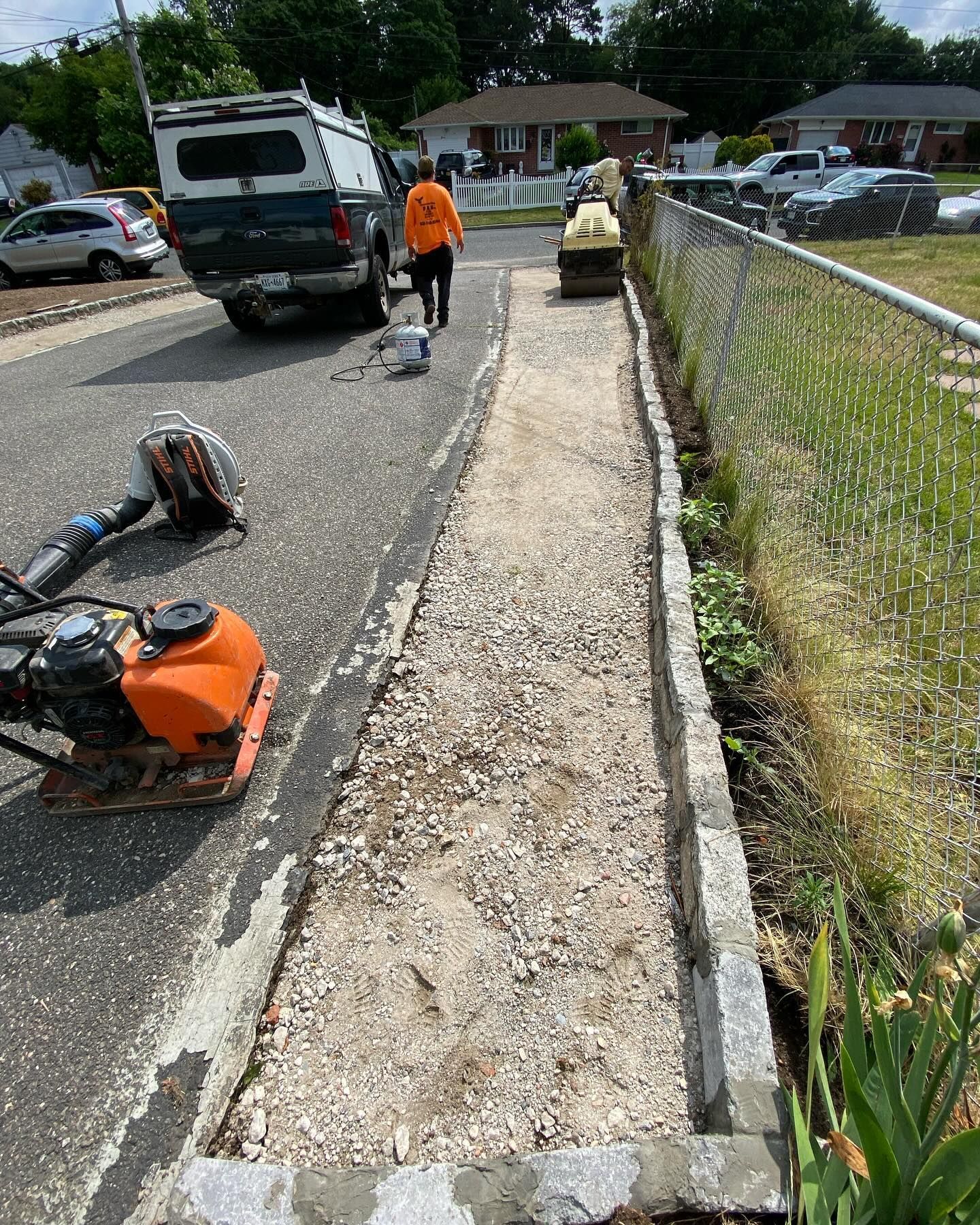 A man is walking down a sidewalk next to a truck.