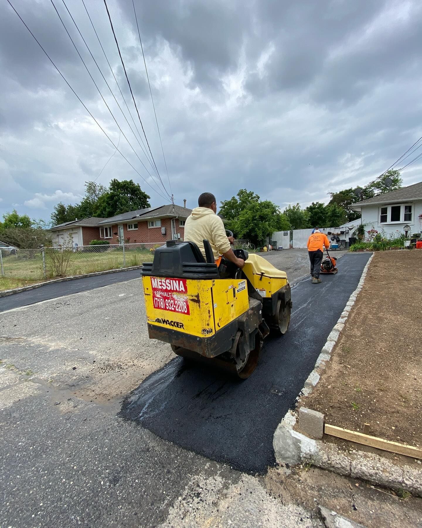 A man is riding a yellow roller on a road.
