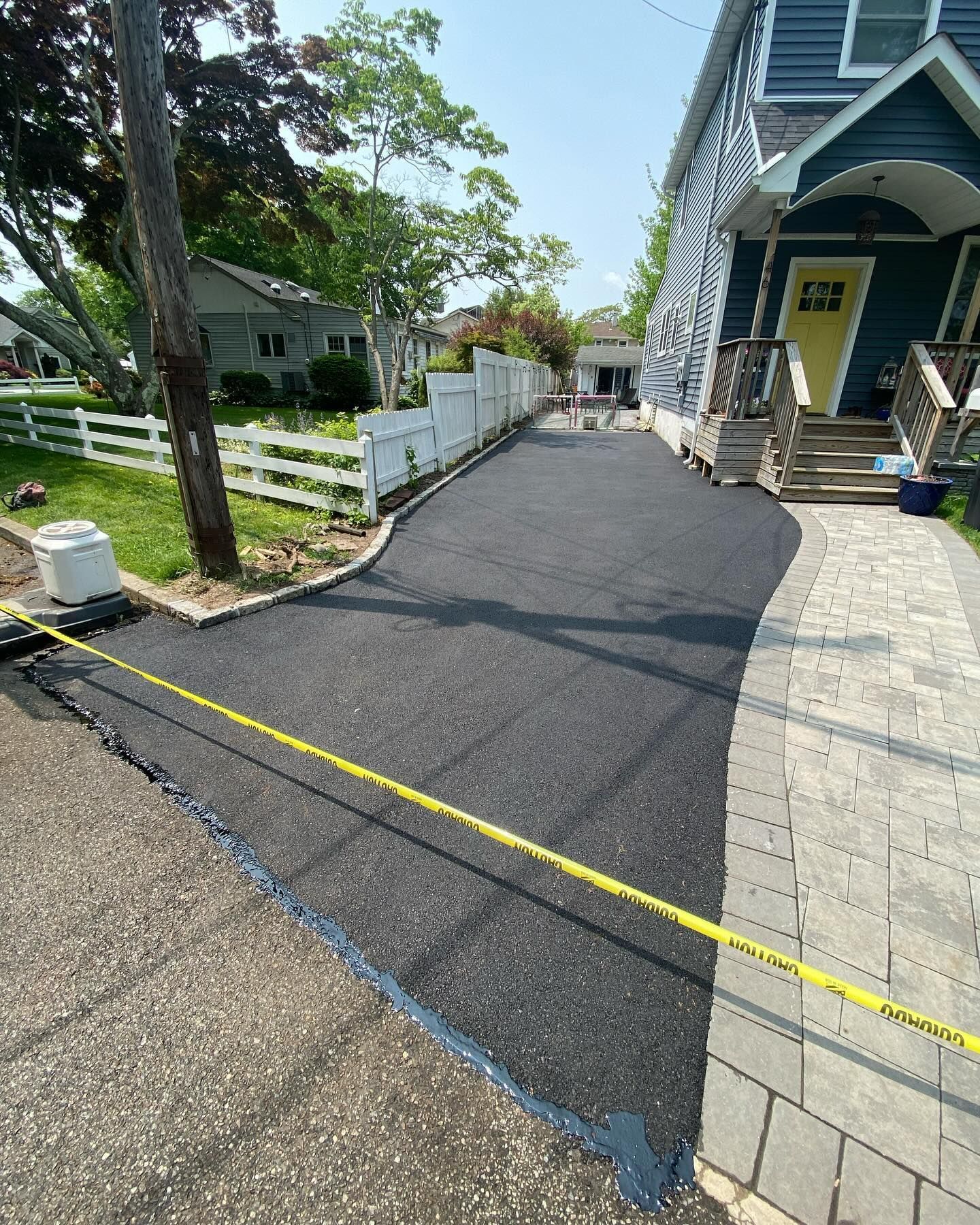 A driveway is being paved in front of a house.