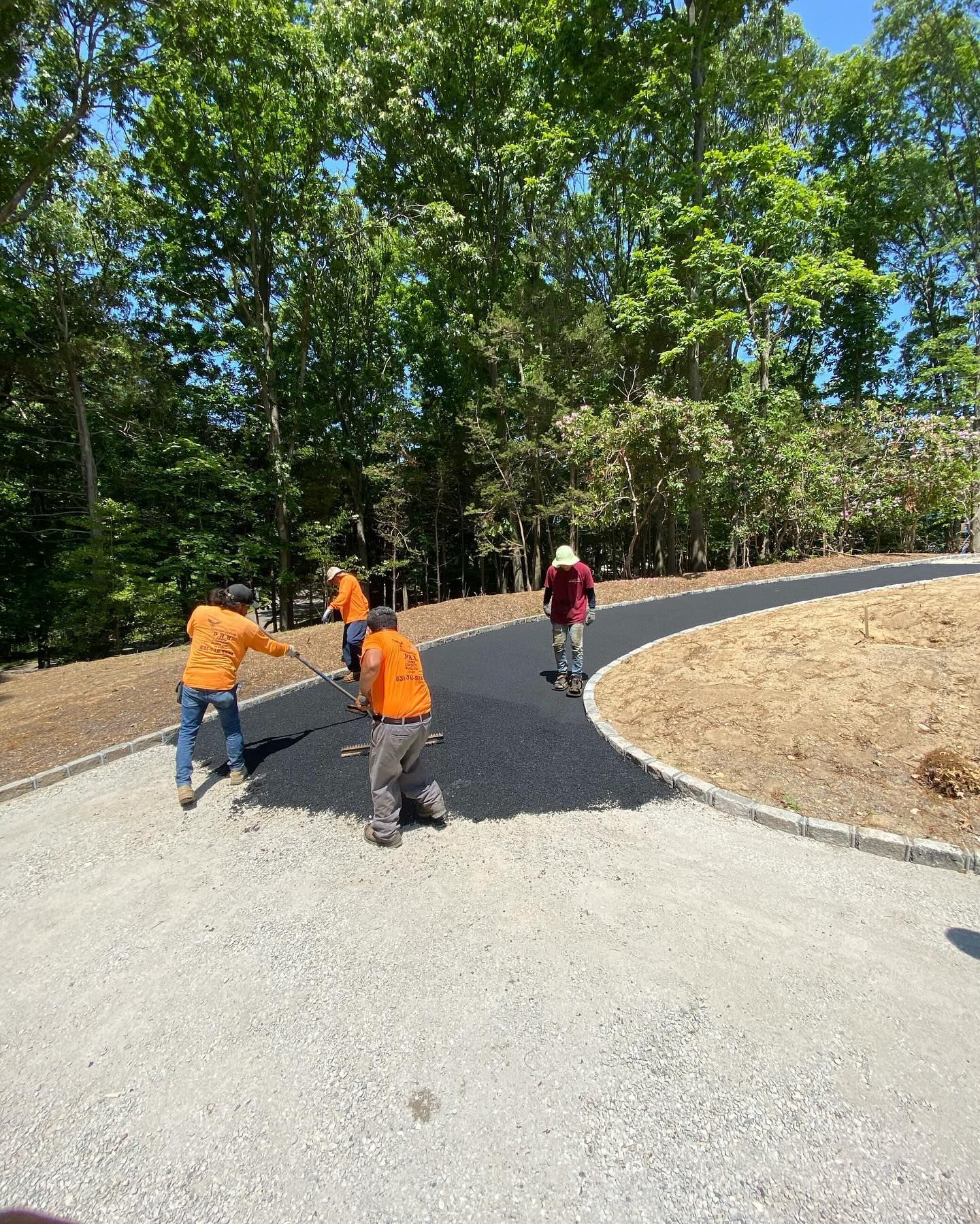 A group of construction workers are working on a road.
